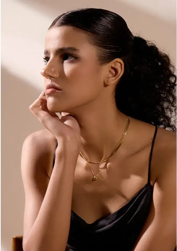 Guldpläterat halsband med fina kedjor och ett litet hänge