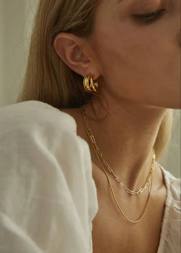 Guldtonad, flerskiktad kedjehalsband med en delikat, sammanflätad länkedesign.