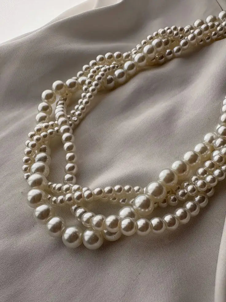 Ett multitrådig halsband med graderade vita pärlor med en glansig, blank finish.